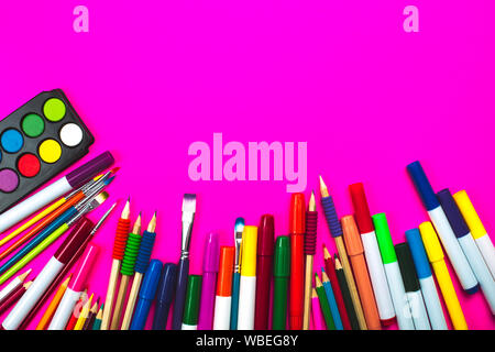 Forniture scolastiche rosa su sfondo al neon e note book con copia spazio. Si torna a scuola concetto. Foto Stock