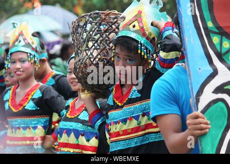 Davao City, Philippines-August 2014: Kadayawan streetcdancing esecutori trasportare puntelli per la loro presentazione. Kadayawan è celebrato agosto di ogni anno Foto Stock