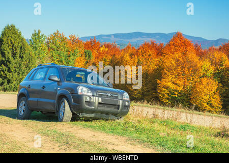 Mizhhirya, Ucraina - Ott 14, 2018: Hyundai Tucson suv sulla ghiaia paese lato strada in montagna. alberi colorati in autunno fogliame sullo sfondo. Foto Stock