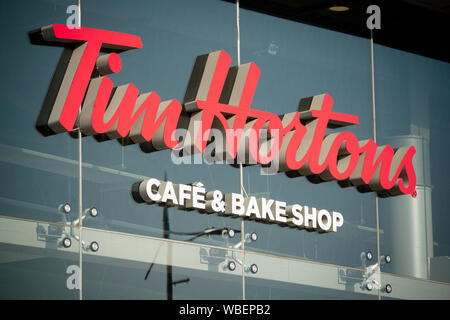 La segnaletica che indica una trasmissione attraverso il ramo del Tim Hortons cafe e bake shop situato su Bury New Road a Manchester, UK. Foto Stock