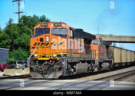 Berwyn, Illinois, Stati Uniti d'America. A Burlington Northern Santa Fe treno di unità di tramoggia vuota vetture guidato da due unità di locomotiva. Foto Stock