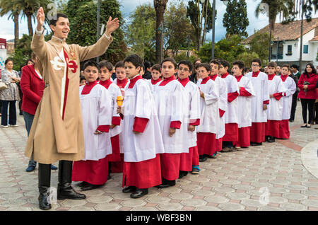 Cuenca, Ecuador - Giugno 4, 2015 - Vice parroco cattolico sacerdote partecipante parla ai giovani ragazzi prima di Corpus Cristi processione Foto Stock