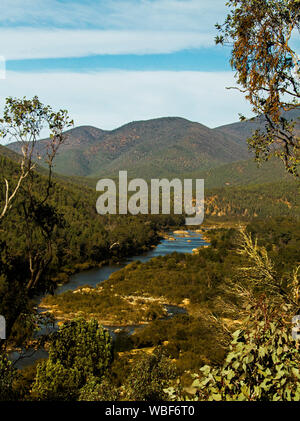 Vista delle gamme di foreste alpine del Parco Nazionale con il blu delle acque del fiume nevoso nella profonda valle di gran lunga al di sotto in Victoria Australia Foto Stock