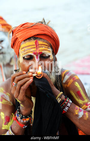 Un Shaiva Sadhu Chillum fumare sul fiume Gange a Varanasi (India). Foto Stock
