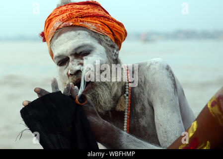 Un Shaiva Sadhu Chillum fumare sul fiume Gange a Varanasi (India). Foto Stock