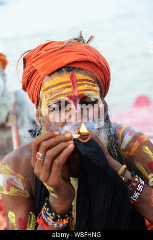 Un Shaiva Sadhu Chillum fumare sul fiume Gange a Varanasi (India). Foto Stock
