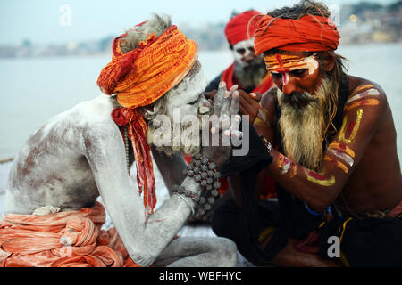 Un gruppo di Shaiva Sadhus Chillum fumare sul fiume Gange a Varanasi (India). Foto Stock