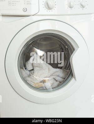 Macchina di lavaggio caricata con vestiti di close-up servizio lavanderia. Il lavaggio della biancheria. Foto Stock