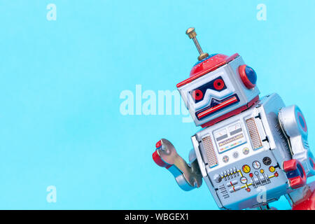 Antico giocattolo di stagno robot su sfondo blu. Vintage e concetto classico copia libera spazio per il testo. Foto Stock
