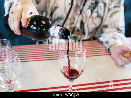 Pechino, Cina. 26 Ago, 2019. Un membro del personale si versa vino per gli ospiti presso lo stand del vino di Bordeaux al vertice del G7 premere centro di Biarritz, Francia su agosto 26, 2019. Credito: Gao Jing/Xinhua/Alamy Live News Foto Stock