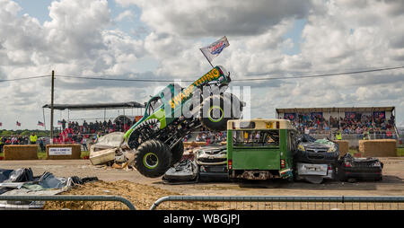 Il monster truck Swamp Thing saltando su alcune vetture durante la dimostrazione su un monster truck show a Santa Pod raceway Foto Stock