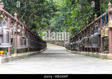 Passaggi Pedonali con molte antiche campane di bronzo su entrambi i lati a Phra That Doi Tung Tempio. Foto Stock