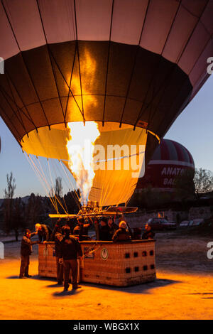 Goreme, Turchia - 6 Aprile 2016 - Pilota incendi il riscaldatore in mongolfiera come egli lo prepara per il volo Foto Stock