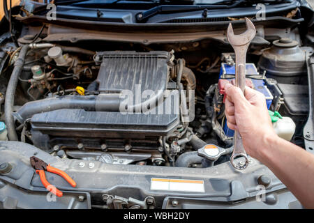 Meccanico Automotive mano azienda chiave al garage. Foto Stock