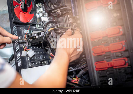 Giovani man mano che tiene il cacciavite per la riparazione del computer. Il tecnico l'aggiornamento hardware del computer. Foto Stock