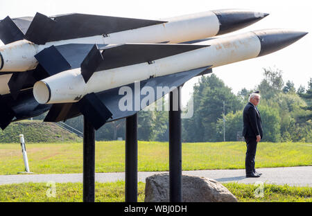 Cammin, Germania. Il 27 agosto, 2019. Il Presidente federale Frank-Walter Steinmeier sorge accanto ai missili Hawk durante la sua visita alla tedesca Air Force. Steinmeier informa di sé circa i compiti e le capacità di difesa aerea gruppo missile 21 con circa 550 soldati. Come parte del sistema integrato di sistema di difesa aerea, l'associazione contribuisce alla protezione dello spazio aereo con il patriota ground-based Air Defence System. Credito: Jens BŸttner/dpa-Zentralbild/dpa/Alamy Live News Foto Stock