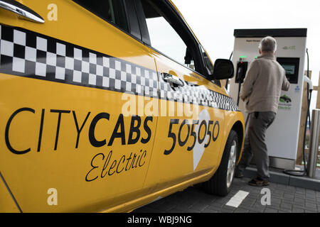 James Leaburn, taxi driver, carica il suo veicolo elettrico taxi a Princes Street la ricarica elettrica ferroviaria, uno dei tre di tali stazioni in città, in Scozia, il 14 agosto 2019. Foto Stock