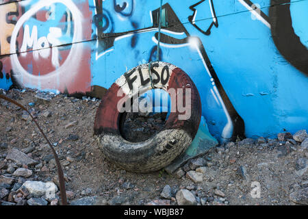 Pneumatico vecchio parafango accanto a un abbandonato e coperto di graffiti di navi su terreno di Sompasaari a Helsinki in Finlandia Foto Stock