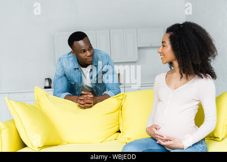 Africana incinta donna americana guardando il fidanzato Foto Stock