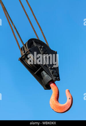 Il gancio della gru isolata contro un cielo blu chiaro. Foto Stock