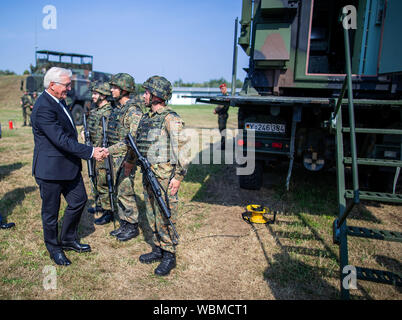 Cammin, Germania. Il 27 agosto, 2019. Il Presidente federale Frank-Walter Steinmeier (M) parla con i soldati durante la sua visita alla forza dell'aria. Steinmeier informa di sé circa i compiti e le capacità di difesa aerea gruppo missile 21 con circa 550 soldati. Come parte del sistema integrato di sistema di difesa aerea, l'associazione contribuisce alla protezione dello spazio aereo con il patriota ground-based Air Defence System. Credito: Jens BüŸttner/dpa-Zentralbild/dpa/Alamy Live News Foto Stock