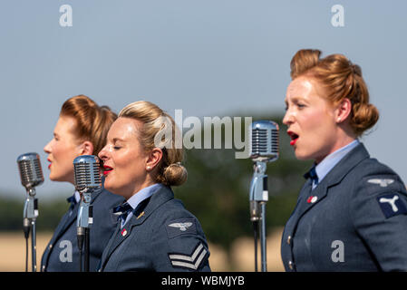 Il D-Day darlings di eseguire presso i bambini hanno bisogno di poca aria Gransden e Auto Show. Katie Ashby leader di un trio di femmine cantando canzoni di guerra Foto Stock