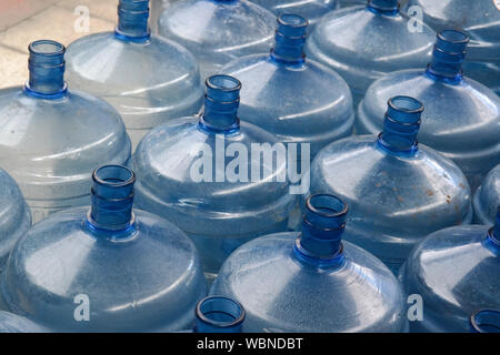 Grande vuoto in plastica bottiglie di acqua per lo scambiatore di calore sono impilati in magazzino esterno. Foto Stock