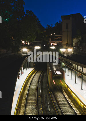 Metro treno lascia l'Acropoli la stazione della metropolitana nel centro storico di notte Foto Stock