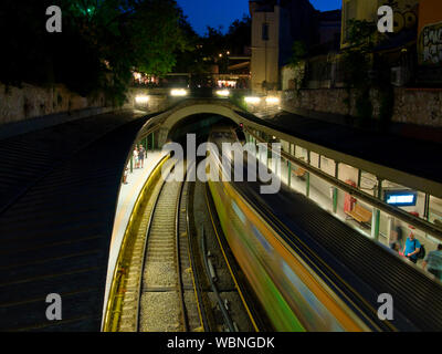 I cittadini in attesa di treno in Acropolis stazione della metropolitana nel centro storico di notte Foto Stock