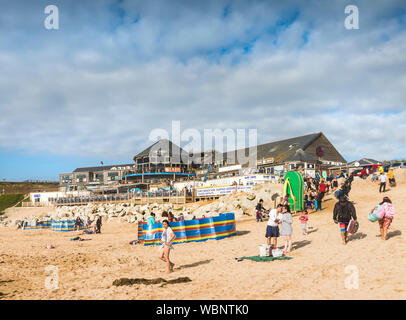 I turisti sulla Fistral Beach e godendo il tardo pomeriggio di sole in Newquay in Cornovaglia. Foto Stock