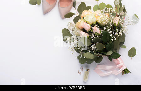 Brides bouquet con scarpe da donna su sfondo bianco Foto Stock