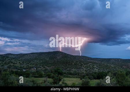 Il fulmine colpisce dietro una collina nella valle Mimbres del New Mexico Foto Stock