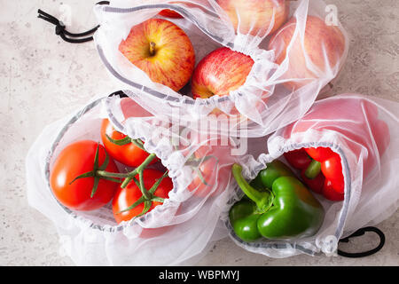 Mele pomodori peperoni verdure in maglia riutilizzabili sacchetto di nylon, plastica libera zero rifiuti Nozione Foto Stock