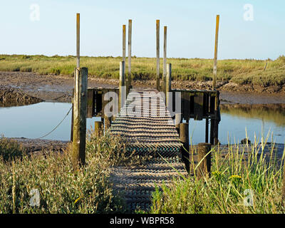 Un rustico pontile in legno a Morston Creek, parte dell'importante area di paludi salmastre sulla Costa North Norfolk dietro Blakeney Point. Foto Stock