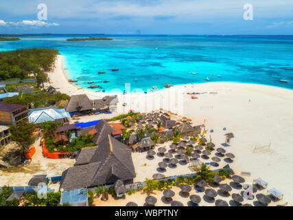 Vista aerea della spiaggia sabbiosa tropicale con palme e ombrelloni, mare Foto Stock