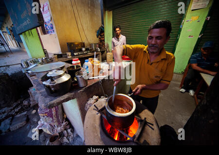 Uomo indiano la preparazione di cibo sul streetat Golabrai area, Rudraprayag town, Kumaon Hills, Uttarakhand, India Foto Stock