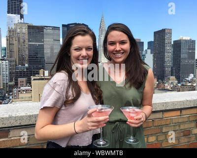 Due amici del college della metà degli anni '20 che si godono un Cosmopolitan su una terrazza dell'Apartment House a Murray Hill, New York, USA Foto Stock