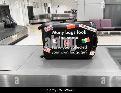 Un promemoria per i passeggeri in attesa per i bagagli in aeroporto giostra di prelevamento valigia corretta. Aeroporto di Manchester. Regno Unito Foto Stock