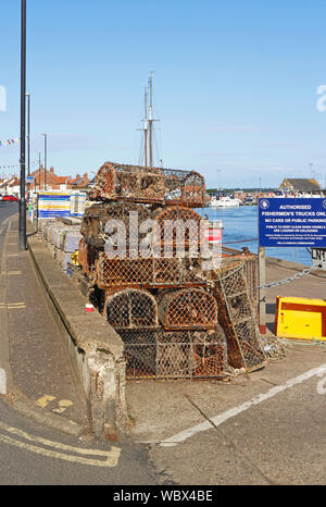Il granchio bicchieri impilati sul Quayside presso il North Norfolk porto di pozzetti-next-il-Mare, Norfolk, Inghilterra, Regno Unito, Europa. Foto Stock