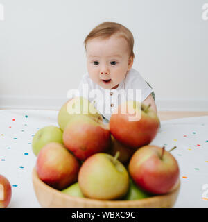 Immagine di un bambino con le mele in un cesto Foto Stock