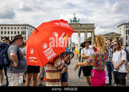 Turisti e visitatori presso la Porta di Brandeburgo, offerta per un tour gratuito in spagnolo, Berlino Foto Stock