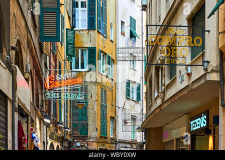 Genova, Italia - Luglio 06, 2019: la vecchia strada con cartelli di negozi e caffè a Genova Foto Stock