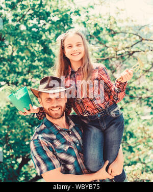 Ecologia Ambiente. suoli e fertilizzanti. molla village country. azienda di famiglia. agricoltura. bambina uomo felice papà. La giornata della terra. nuova vita. padre e figlia sul ranch. Questo è il mio preferito fiore. Foto Stock