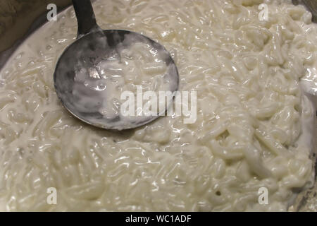 Thai dessert, riso tagliatelle fatte di riso mangiato con latte di cocco nella pentola grande preparare per vendere nel mercato. Immagine ad alta risoluzione gallery. Foto Stock