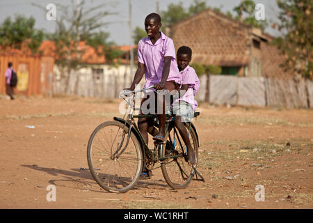 TORIT, SUD SUDAN-febbraio 20, 2013: Unidentified scolari cavalcare la loro moto dalla scuola in sud Sudan Foto Stock