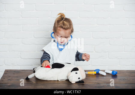 Bambino veterinario esamina toy animale con uno stetoscopio Foto Stock