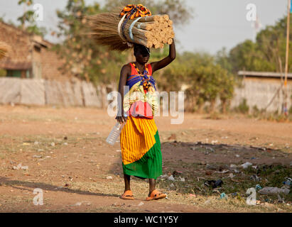 TORIT, SUD SUDAN-febbraio 20 2013: donna non identificato trasporta un carico pesante sulla sua testa in Torit, Sud Sudan. Foto Stock