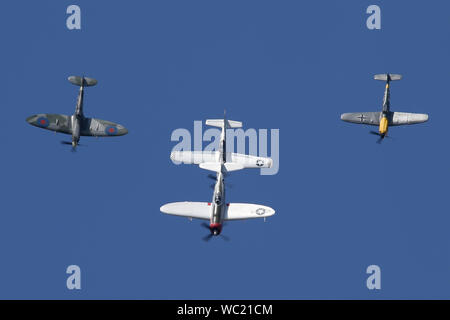 Il "Storico fighters' team di quattro guerra mondiale due combattenti, P-51, P-47, Spitfire e Buchon nella formazione di overhead aviosuperficie Wattisham. Foto Stock