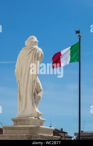 Statua in Piazza Grande a Palmanova, Italia, bandiera italiana in background Foto Stock