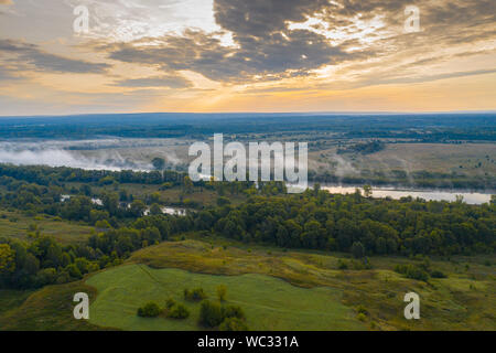 Vista aerea di smog sopra la città di risveglio all'alba, in edifici di distanza coperta di nebbia e smog Foto Stock